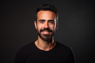 Portrait of a handsome bearded man in a black t-shirt on a dark background