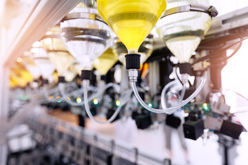 Perfume manufacturing process, conveyor line belt of modern facility bottling aroma oil in clear...