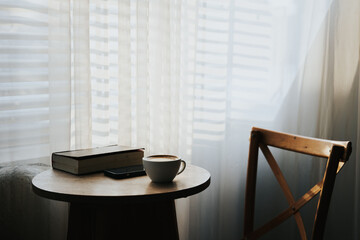 Relaxation corner, latte cup and headphones Books on a wooden table in a coffee shop or house. Vintage colors.