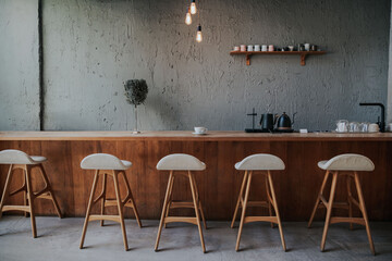 Wooden counter or bar Coffee shop with coffee equipment and wooden shelves, rough cement...