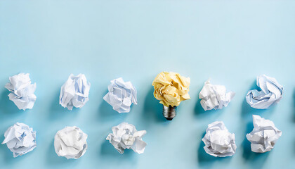 A bright idea concept, yellow crumpled paper light bulb amidst white crumpled papers on a blue background, symbolizing ideas, brainstorming, and creativity.