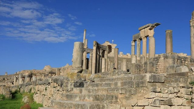 Ancient Roman ruins in Dougga with blue skies, showcasing history and architecture