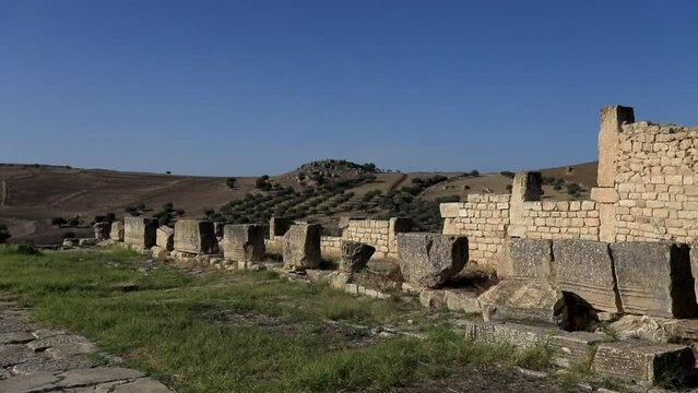 Ancient Roman ruins in Dougga against a clear blue sky, sunny day