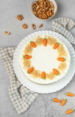 Homemade carrot cake made with walnuts, iced with cream cheese. Sweet dessert.