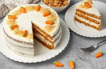 Homemade carrot cake made with walnuts, iced with cream cheese. Sweet dessert.