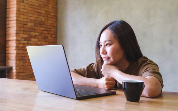 Portrait image of a young woman working and looking at laptop computer