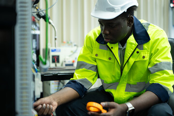 Portrait of a technician working with a digital multimeter to test the electrical system of a huge...