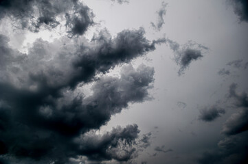Dramatischer grau-weißer Wolkenhimmel mit Sturmbewölkung und vorüberziehenden Wolkenfetzen eines schweren Unwetters
