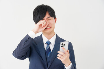 スマートフォンを持って泣くビジネスマン　白背景
