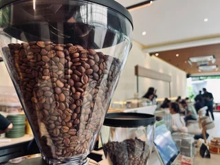 Foto op Plexiglas Espresso coffee maker grinder machine working in cafe and coffee shop, blur background. Business food and drinks concept. © Namu Stock