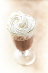 Coffee with whipped cream on bright stone background. Soft focus. Close up.	