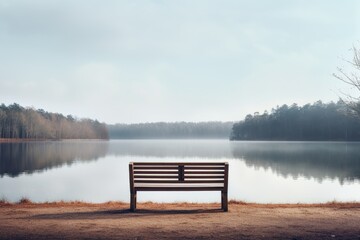 Fototapeta na wymiar Morning on the lake, Photograph of an empty bench overlooking a calm lake, bench on the lake