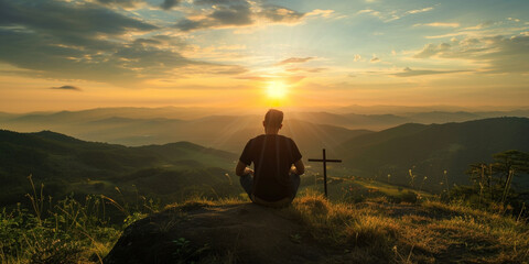 Silhouette of a man sitting on high hill with cross during sunrise or sunset. Regretting sins, missing people who passed away, deeply religious person, praying, thinking about soul and meaning of life - obrazy, fototapety, plakaty