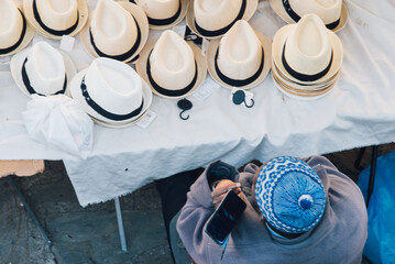 Africain téléphonant à son étal de chapeaux. Africain vendant des chapeaux sur un marché...