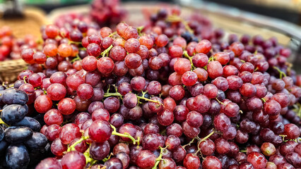 Bunch of Red seedless grapes. Pile of fresh grape in a local market in Thailand, Organic bunch of grapes in supermarket. Fresh grape on basket, Grape background. fruit store.