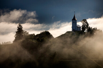Jamnik, Slovenia - Magical foggy golden summer sunrise at Jamnik St.Primoz church.