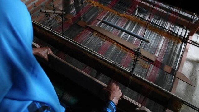 A woman from Aceh, Sumatera, Indonesia is working on making traditional woven fabric