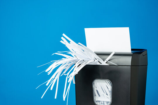 Office paper shredder on blue studio background