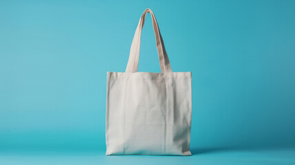 A plain white canvas tote bag stands against a bright blue background, highlighting its simplicity and reusable nature.