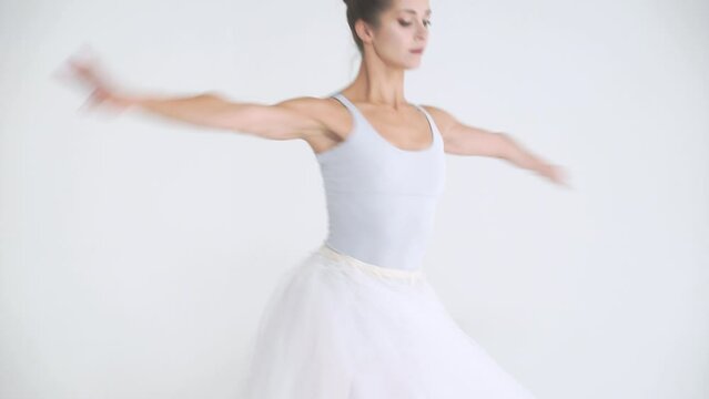 Dramatic dance, elegant female in a white tutu, dance ballet and perform choreographic elements on a white background, rehearsal.