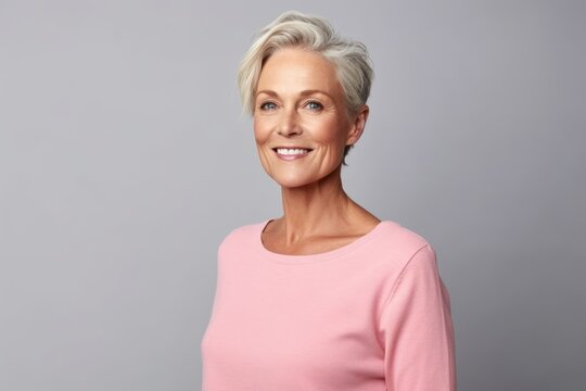 Mature woman in pink sweater. Portrait of beautiful mature woman smiling and looking at camera