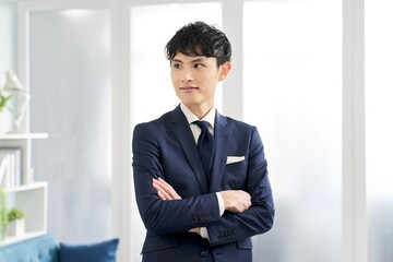 オーダースーツを着て腕組みをするビジネスマン
