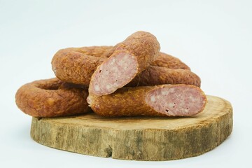 Fototapeta na wymiar Meat dish sausage on a wooden board. The product is ready to use. White background.