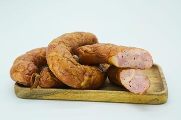Meat dish sausage on a wooden board. The product is ready to use. White background.