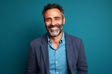 Portrait of a handsome middle-aged man smiling against blue background