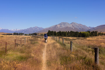 Tourist with backpack walks towards montains