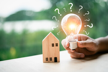 Investment in real estate Borrowing loan to buy a house or rent it out and profit from the mortgage Property or house, investment risk and return, house model and bright light bulb with question mark. - obrazy, fototapety, plakaty