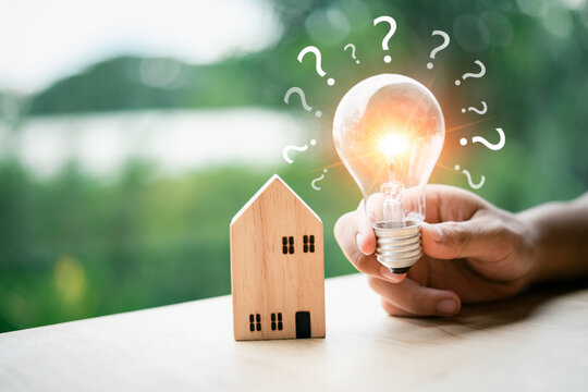 Investment in real estate Borrowing loan to buy a house or rent it out and profit from the mortgage Property or house, investment risk and return, house model and bright light bulb with question mark.