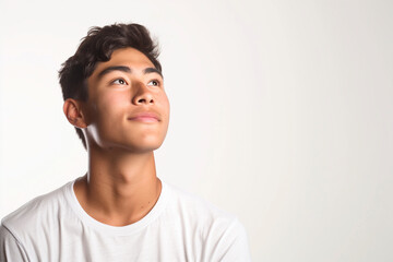 Fototapeta premium A young man, dressed in a simple t-shirt, looking upward with hope.