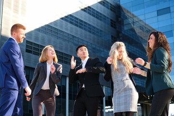 Business people team dancing excited for growth, successful sale or profit target at building area street.