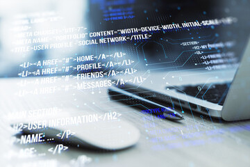 Image showing a modern laptop with digital code overlay depicting software development concepts in the foreground