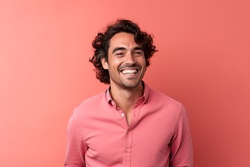 Portrait of a handsome young man with curly hair on a pink background