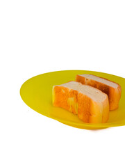 two slices of bread on a yellow plastic plate, isolated on a white background, concept of hunger, poverty and inflation impacting society or humans.