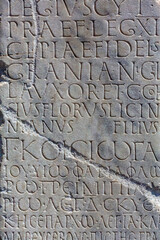 Retro text background. Fragment of ancient inscription (funeral memorial text at Latin and Ancient Greek languages), carved on marble block. Monochrome, vertical. Kayseri, Turkey (Turkiye)