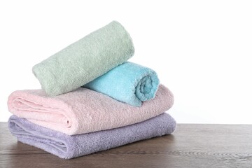 Fototapeta na wymiar Fresh towels on wooden table against white background