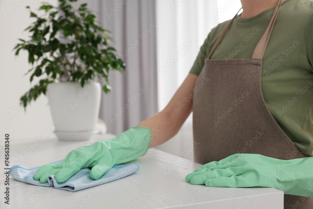 Canvas Prints Woman with microfiber cloth cleaning white table in room, closeup