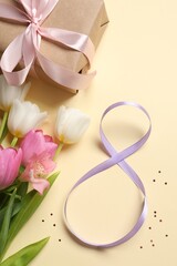 8th of March greeting card design with violet ribbon, gift box and beautiful flowers on beige background. International Women's day