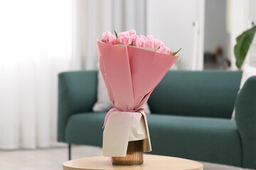 Beautiful bouquet of fresh pink tulips on table at home