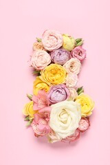 8 March greeting card design made with beautiful flowers on pink background, top view