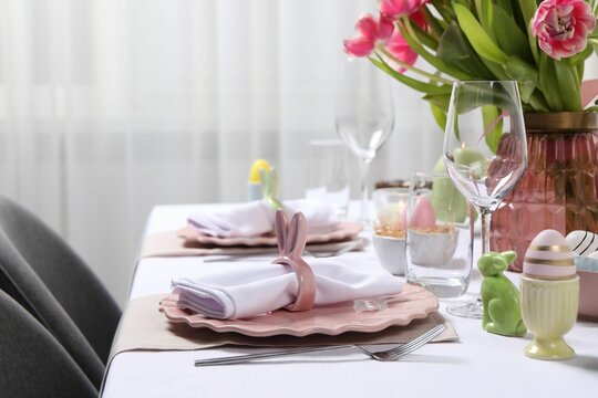 Festive table setting with napkin ring in shape of bunny ears. Easter celebration