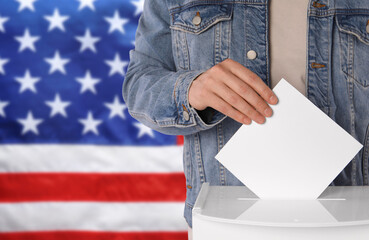 Election in USA. Man putting his vote into ballot box against national flag of United States, closeup. Space for text