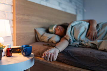 Woman sleeping with sleep mask, using sleeping pills, melatonin. Concept of sleep routine. Insomnia...