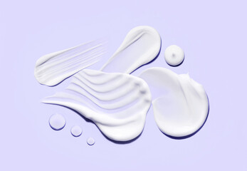 cosmetic smears of creamy texture drops of tonic serum on pastel background