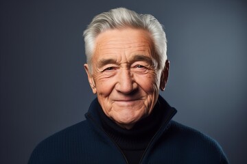 Portrait of a happy senior man with grey hair over dark background