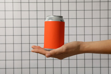 A metal can with a red wrapper in his hands