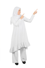 Beautiful Muslim woman in white hijab pointing fingers aside at copy space